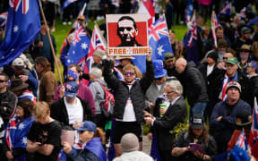 A protester at the Adelaide March for Australia rally holds up a photo of alleged police shooter and fugitive Dezi Freeman.