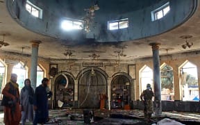 Taliban fighters investigate inside a Shiite mosque after a suicide bomb attack in Kunduz on 8 October 2021.