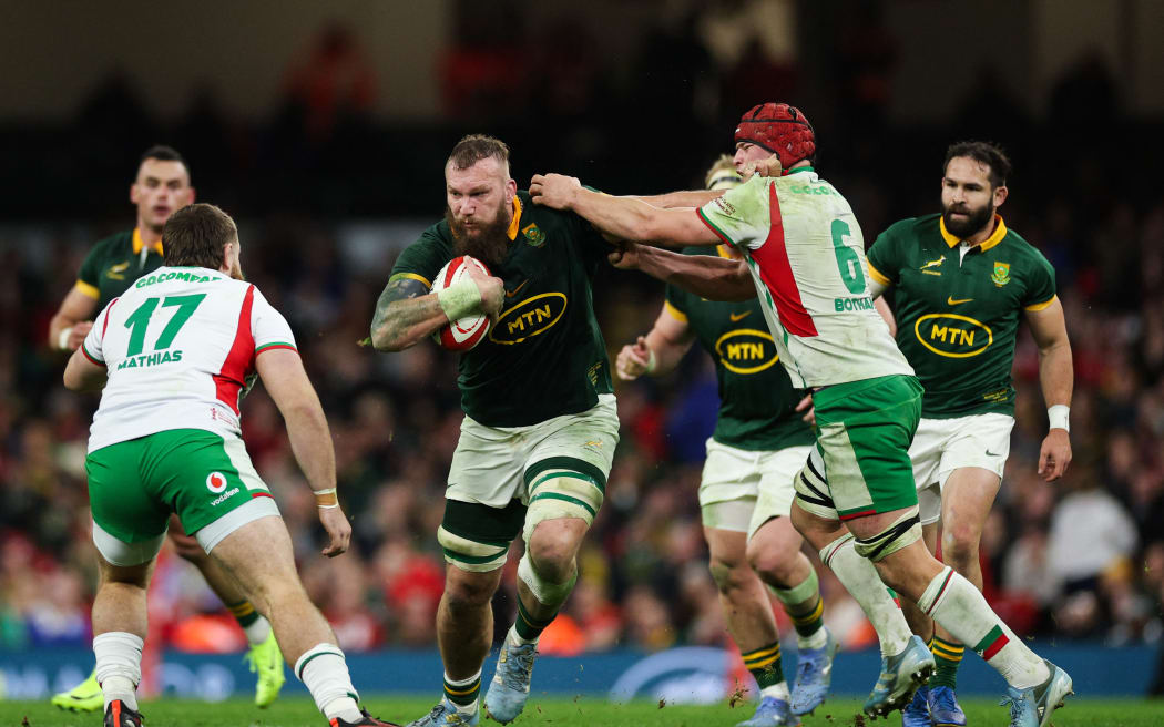 South Africa's RG Snyman (C) is tackled as he runs with the ball during the Autumn Nations Series International rugby union test match between Wales and South Africa at the Principality Stadium, in Cardiff on November 23, 2024. (Photo by Adrian Dennis / AFP) / RESTRICTED TO EDITORIAL USE -USE IN BOOKS SUBJECT TO WELSH RUGBY UNION (WRU) APPROVAL