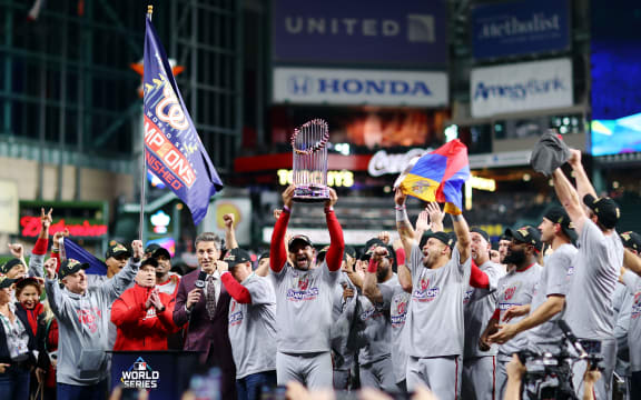 Manager Dave Martinez #4 of the Washington Nationals hoists the Commissioners Trophy after defeating the Houston Astros 6-2 in Game Seven to win the 2019 World Series in Game Seven of the 2019 World Series at Minute Maid Park on October 30, 2019 in Houston, Texas