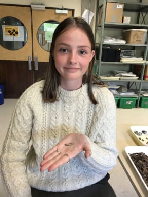 Isla shows the fish hook she has found.