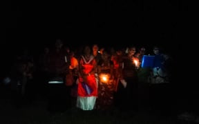 Villagers from Muana, Toga island, in Fiji's Rewa River delta, sing Christmas carols surrounded by floodwaters, December 2016