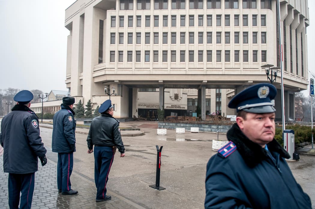 Police on guard in Simferopol after pro-Russian armed men seized the local parliament.