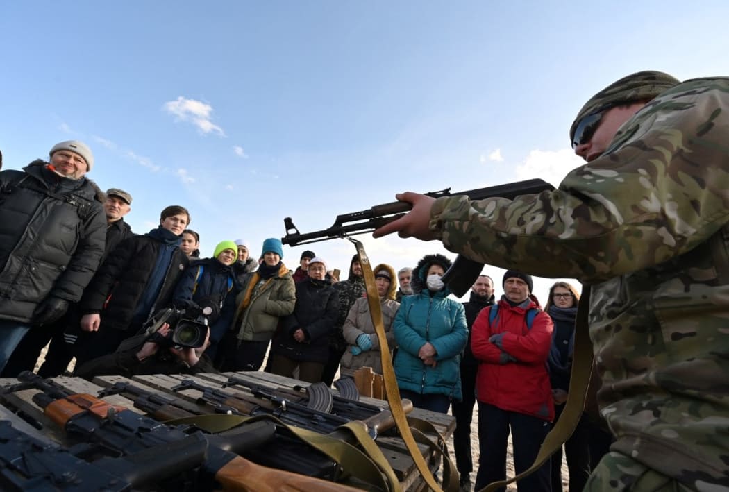 Residents attend an open training organised for civilians by war veterans and volunteers who teach the basic weapons handling and first aid on one of Kiyv's city beaches on February 20, 2022,