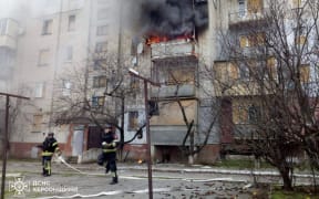 This handout picture taken and released by Ukrainian State Emergency Service on December 26, 2024, shows the firefighters pushing out a fire after a shell explosion in a residential building from a Russian shelling in Bilozerka village, Kherson region, amid Russian invasion in Ukraine.