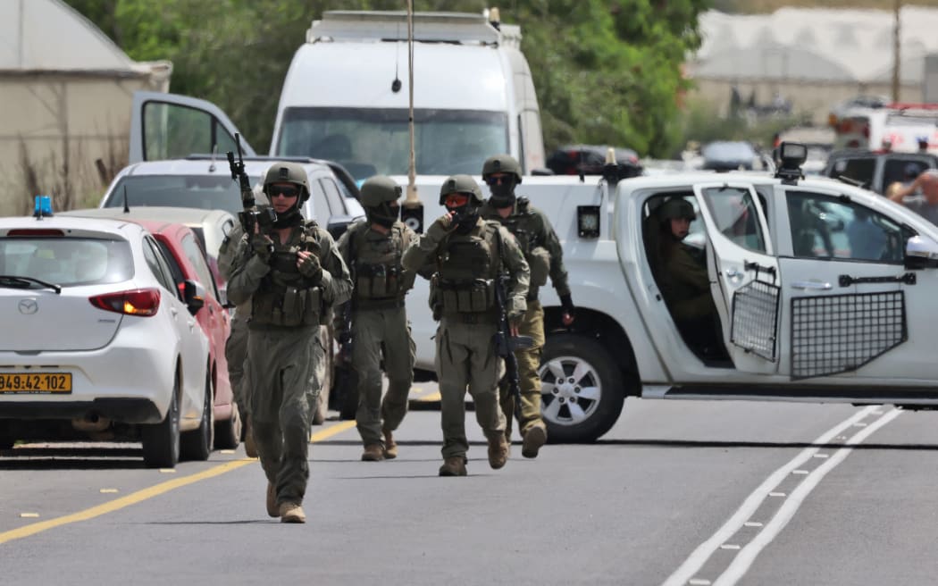 Israeli forces and emergency personnel gather near the Hamra junction, in the northern part of the Jordan valley in the occupied West Bank, following a shooting attack on April 7, 2023. - Two women were killed and another seriously wounded in a shooting attack on a vehicle in the occupied West Bank, Israeli army and medics said on April 7. (Photo by Jaafar ASHTIYEH / AFP)