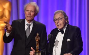US actor Clint Eastwood introduces Argentinian composer Lalo Schifrin (R) accepting an honorary Oscar at the 10th Annual Governors Awards gala hosted by the Academy of Motion Picture Arts and Sciences at the the Dolby Theater at Hollywood & Highland Center in Hollywood, California on November 18, 2018. (Photo by Robyn BECK / AFP)