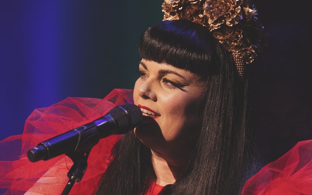 Tami Neilson on stage with guitar and crown!