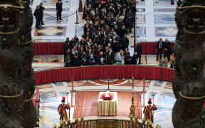 This handout picture taken and released on January 2, 2023 by the Vatican media shows people waiting in line to pay their respect at the body of Pope Emeritus Benedict XVI laying in state at St. Peter's Basilica in the Vatican. - Benedict, a conservative intellectual who in 2013 became the first pontiff in six centuries to resign, died on December 31, 2022, at the age of 95. Thousands of Catholics began paying their respects on January 2, 2023 to former pope Benedict XVI at St Peter's Basilica at the Vatican, at the start of three days of lying-in-state before his funeral.
