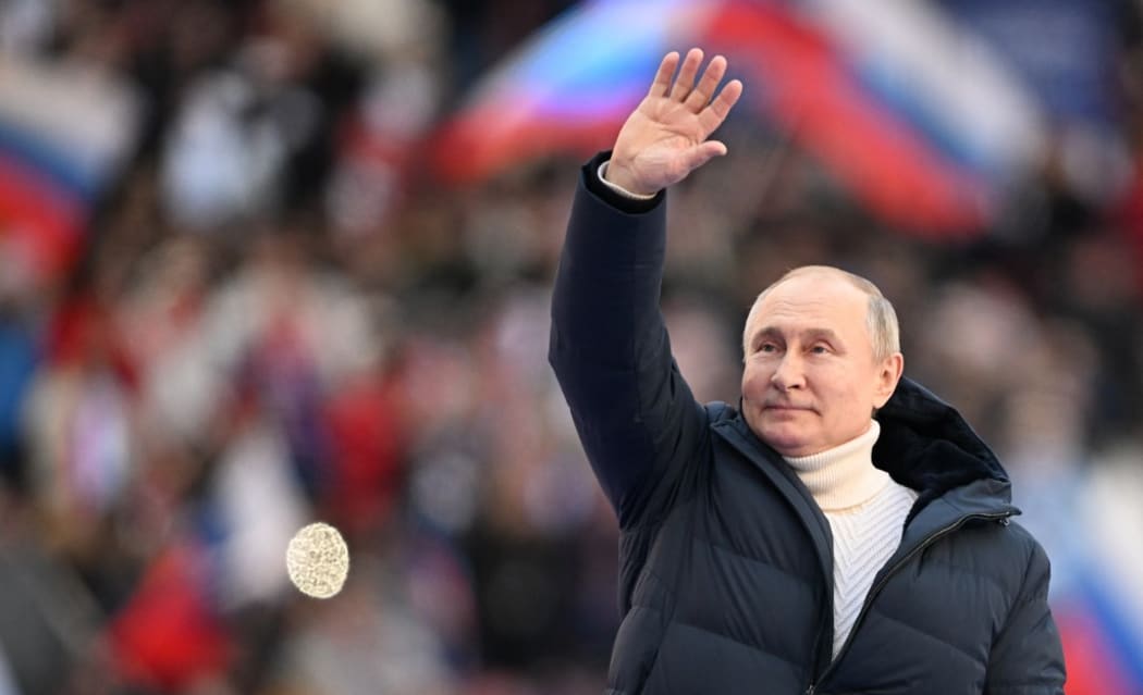 8143885 18.03.2022 Russian President Vladimir Putin waves during a concert marking the 8th anniversary of the referendum on the state status of Crimea and Sevastopol and its reunification with Russia, at Luzhniki Stadium in Moscow, Russia.