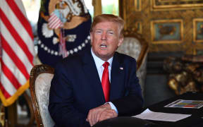 US President Donald Trump answers questions from reporters after making a video call to the troops stationed worldwide at the Mar-a-Lago estate in Palm Beach, Florida.