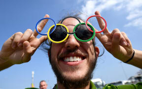 A volunteer wearing olympics rings shaped sunglasses poses ahead of the Rio 2016 Olympic Games in Rio de Janeiro on August 4, 2016. (Photo by FRANCK FIFE / AFP)