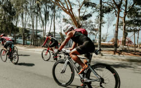 People cycling on a road.