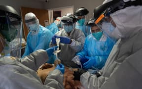 Medical workers wearing personal protective equipment (PPE) treat a patient suffering from the coronavirus disease in the Intensive Care Unit (ICU) of the United Memorial Medical Center in Houston, Texas, the United States.