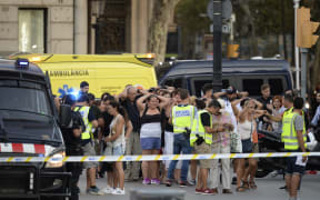 Police check the identity of people after a van ploughed into a crowd in Barcelona.