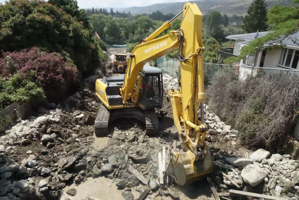 Diggers work in Roxburgh's Reservoir Creek drainage in a race against time before next the downpour.