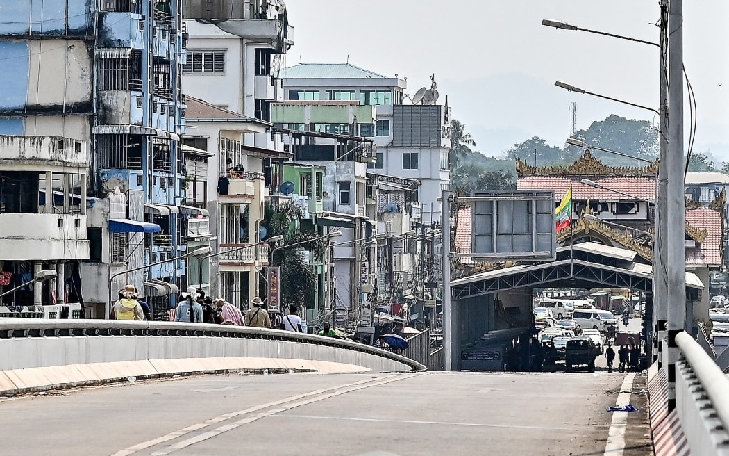 A Myanmar flag flutters over a border control building on the Myanmar side of the Thailand-Myanmar Friendship bridge, as seen from Thailand's Mae Sot district on 12 April, 2024.