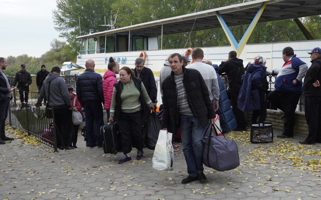 Civilians evacuated from the city of Kherson, which Moscow claims to have annexed, arrive in the neighbouring town of Oleshky after crossing the Dnipro river on a passenger boat on October 25, 2022, days after Kherson pro-Russian authorities urged residents of the region's eponymous main city to leave "immediately" in the face of Kyiv's advancing counter-offensive. (Photo by STRINGER / AFP)