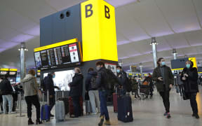 Travellers queue with their luggage in the departures hall at Terminal 2 of Heathrow Airport in west London on December 21, 2020,