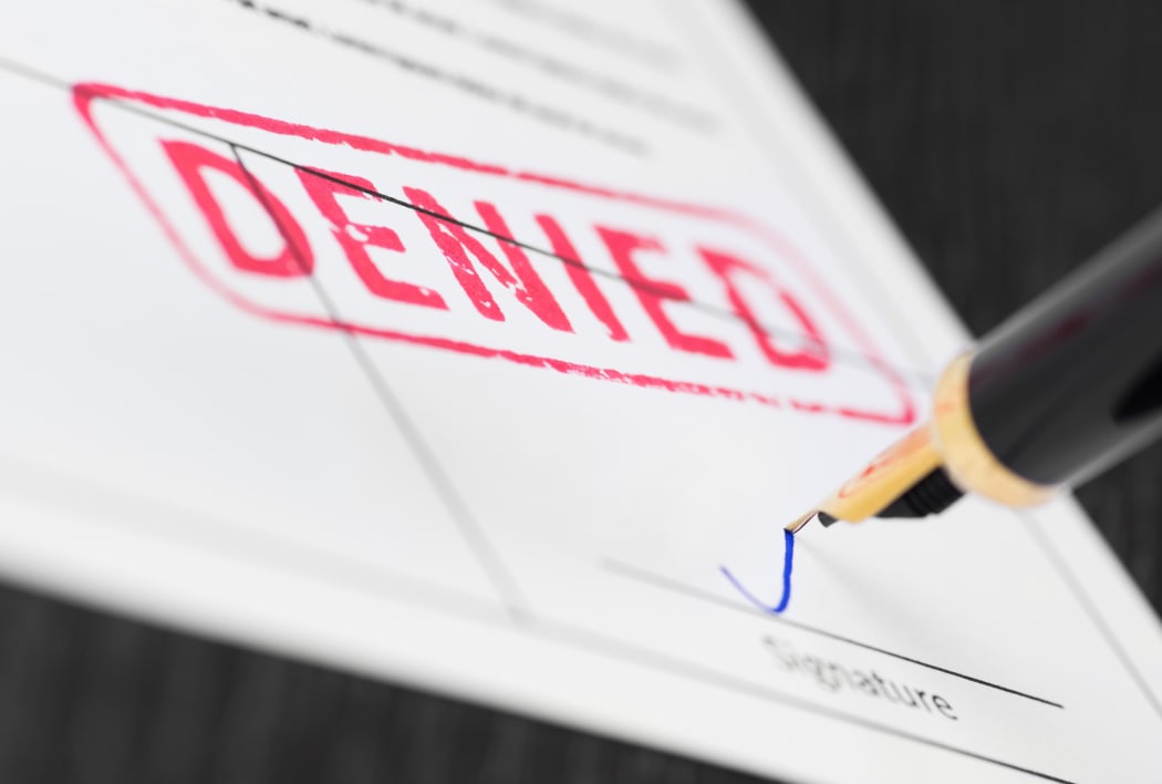 Seal denied stamped on a document and fountain pen. Macro shot.