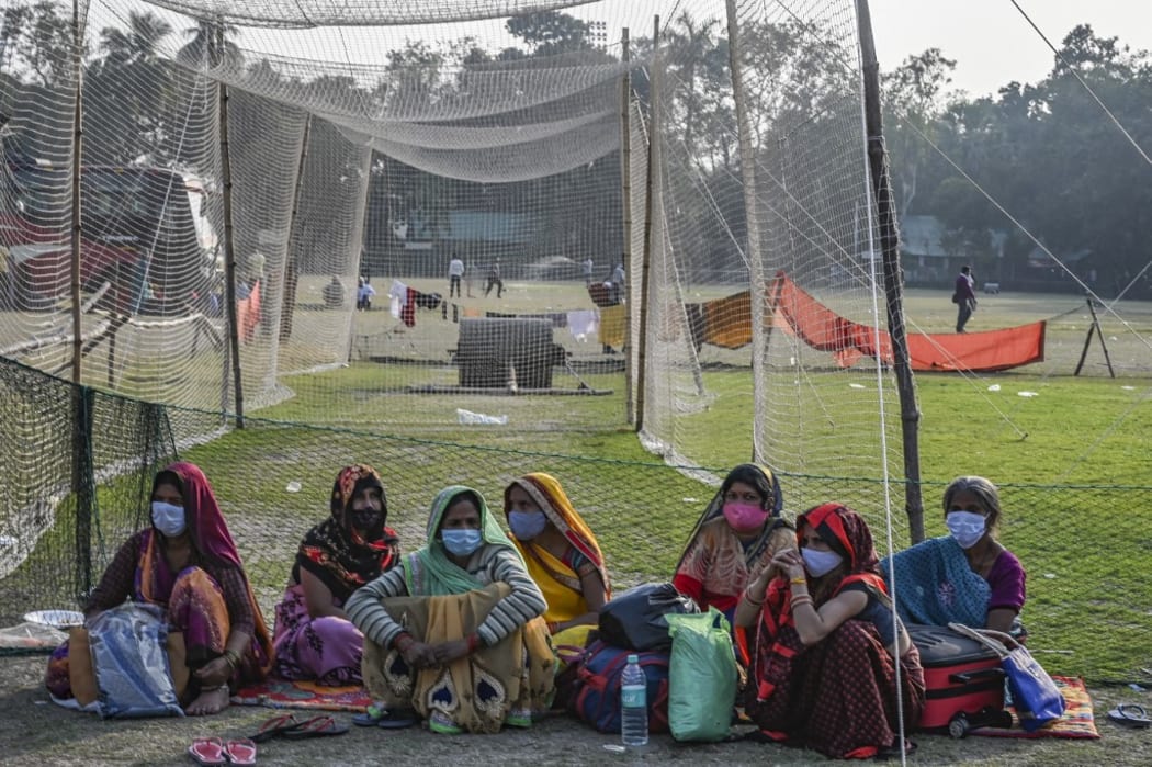 Pilgrims wait for transportation at a transit camp ahead of the upcoming annual Gangasagar Mela or annual religious fair at the Sagar Island, in Kolkata on January 8, 2022.