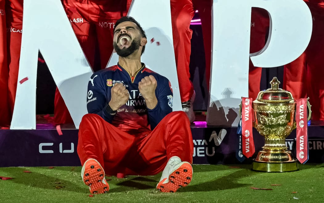 Royal Challengers Bengaluru's Virat Kohli reacts while sitting beside the trophy after winning the Indian Premier League (IPL) Twenty20 final cricket match against Punjab Kings at the Narendra Modi Stadium in Ahmedabad on June 4, 2025. (Photo by Arun SANKAR / AFP) / -- IMAGE RESTRICTED TO EDITORIAL USE - STRICTLY NO COMMERCIAL USE --