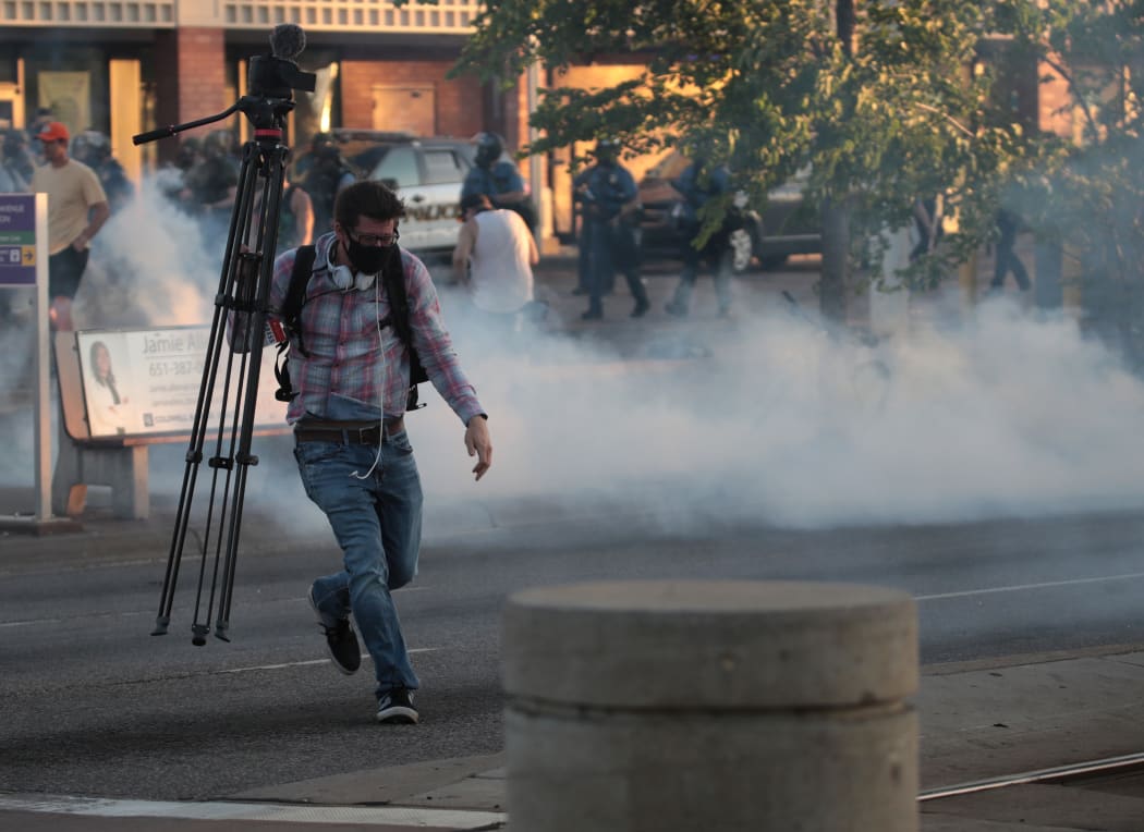 A member of the media runs through tear gas during a protest on May 28, 2020 in St. Paul, Minnesota.