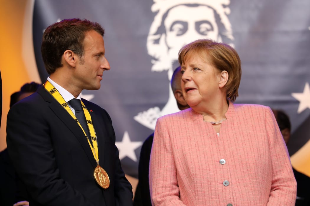 France's President Emmanuel Macron stands next to German Chancellor Angela Merkel at the end of the Charlemagne prize award ceremony on May 10, 2018 in Aachen, western Germany.