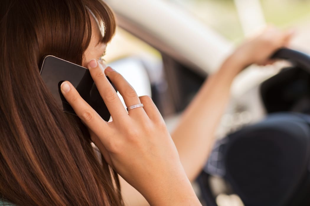 transportation and vehicle concept - woman using phone while driving the car