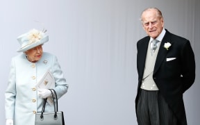 Queen Elizabeth II and Britain's Prince Philip, Duke of Edinburgh wait for the carriage carrying Princess Eugenie of York and her husband Jack Brooksbank to pass at the start of the procession after their wedding ceremony at St George's Chapel, Windsor Castle.