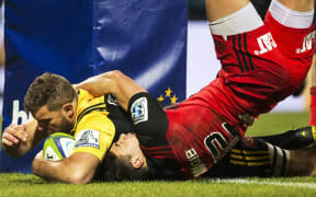 Callum Gibbins scores in the embrace of David Havili.