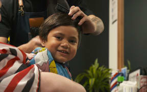 A boy at Ōtara's Bubblegum youth hub gets a haircut and a chat, as well as study help.