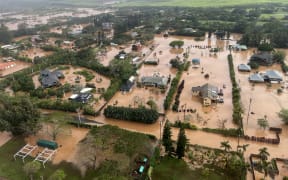 This handout photo released by the US Coast Guard, via DVIDS on March 21, 2026, shows a flooded neighborhood in Waialua on the north shore of Oahu, Hawaii, during a crew flyover with a MH-65 Dolphin helicopter assigned to Coast Guard Air Station Barbers Point in Kapolei, on March 20, 2026. Officials in Hawaii on March 20 ordered some 4,000 people living near an aging dam on the island of Oahu to evacuate the area immediately, following severe rains that have battered the region. The century-old Wahiawa dam, located in the north of Hawaii's third largest island, which is home to the state capital Honolulu, "is at imminent risk of failure," the local emergency management agency warned. (Photo by HANDOUT / US Coast Guard / AFP) / RESTRICTED TO EDITORIAL USE - MANDATORY CREDIT "AFP PHOTO / US COAST GUARD" - HANDOUT - NO MARKETING NO ADVERTISING CAMPAIGNS - DISTRIBUTED AS A SERVICE TO CLIENTS