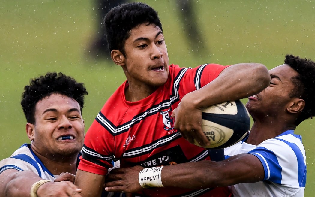 Kelston Josefa Kolinisau looks to offload as he's tackled during a match against St Kentigern.
Kelston Boys High School v St Kentigern, Auckland Rugby First XV 1A Competition, 2017.