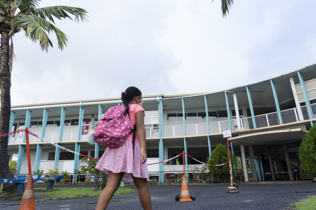 Schoolchildren wearing protective face masks arrive at the Taimoana Primary school in Papeete