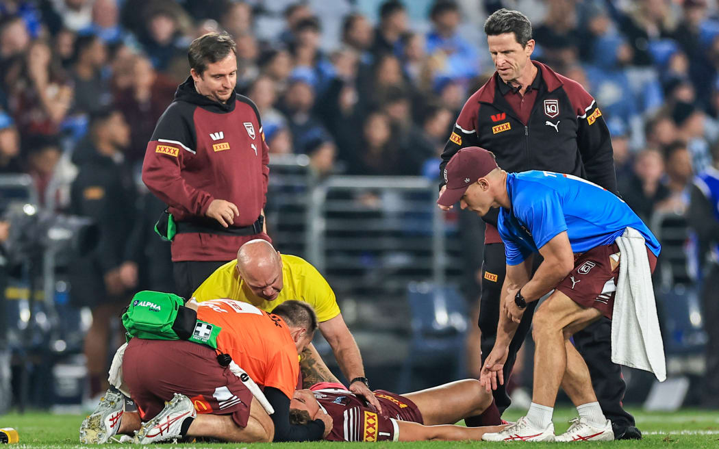 Reece Walsh of the Maroons is attended to after been tackled by Joseph-Aukuso Sua'ali'i of the Blues during Game 1 of the State of Origin 2024