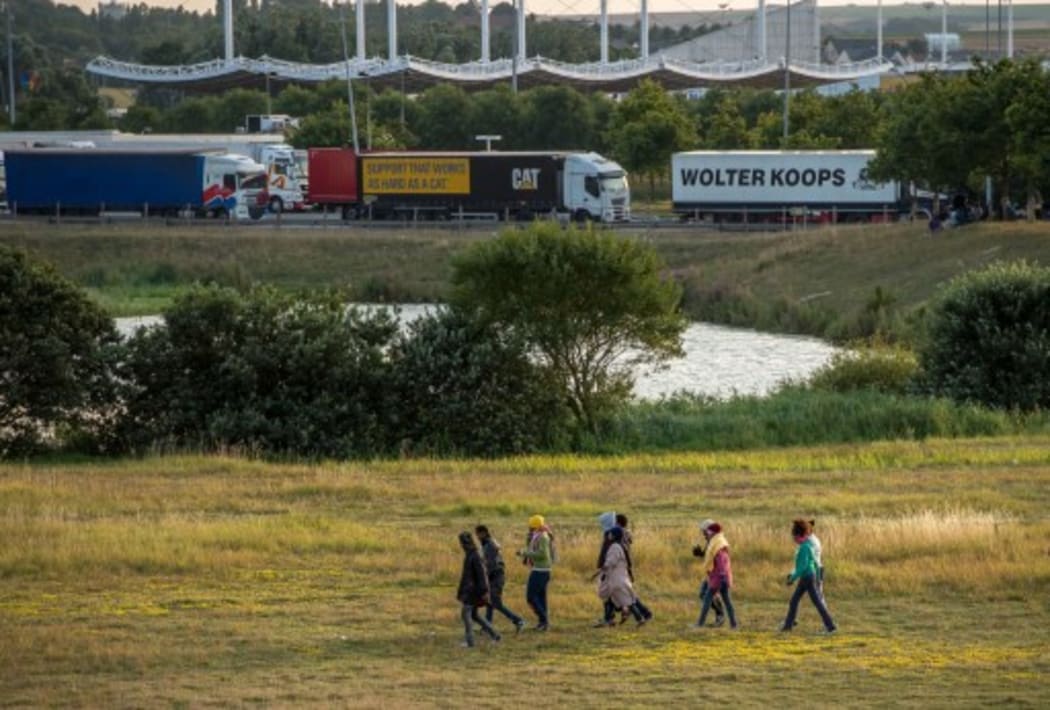 Migrants try to enter inside the Eurotunnel site to attempt to reach Britain, in Coquelles near Calais, northern France, on July 31, 2015.