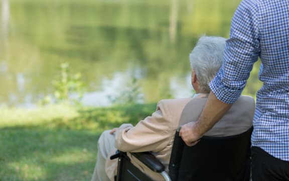 Photo of elderly man on wheelchair and his private carer
