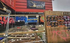 The front of a building that has rubbish strewn in front of it.
