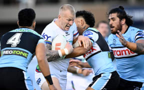 Mitchell Barnett of the Warriors is tackled by Niwhai Puru of the Sharks during the NRL Pre-Season Challenge Round 1 match between the Cronulla Sutherland Sharks and the New Zealand Warriors at Shark Park in Sydney, Friday, February 7, 2025.  (AAP Image/Dan Himbrechts/Photosport)
