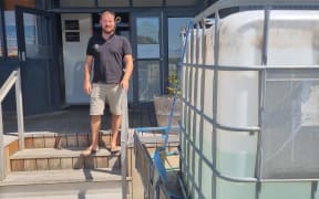 Restaurant Wharf owner and manager Grant Fussell drove a trailer to work with a 1000-litre drum of his home tank water.