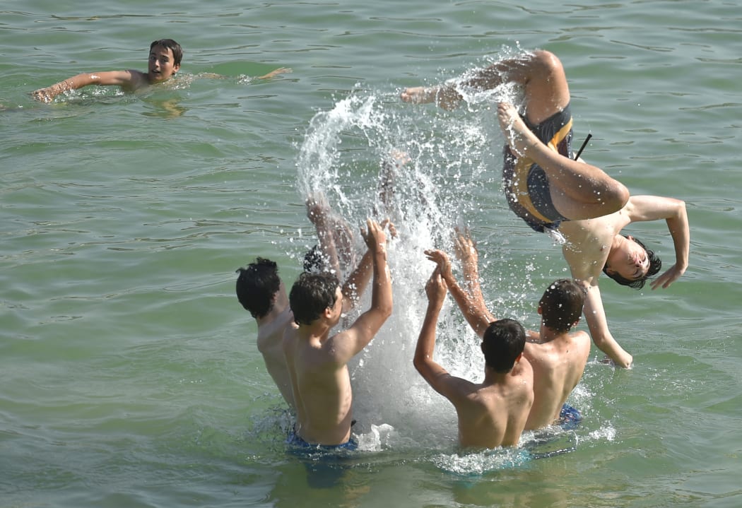 Youngsters cool off at La Concha beach in the northern Spanish city of San Sebastian on June 26, 2019.
