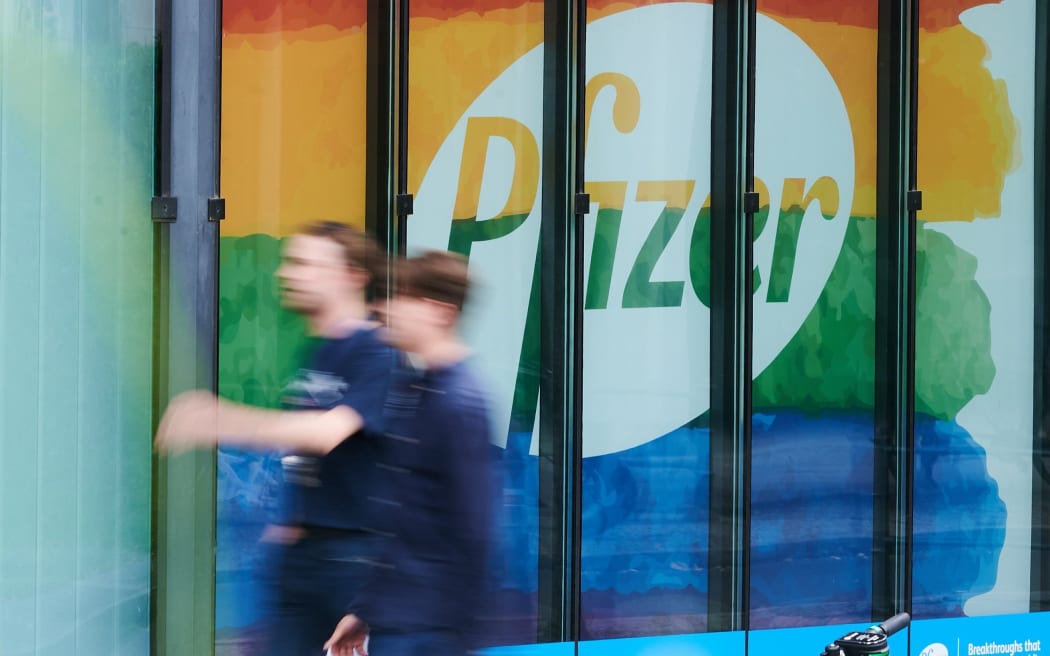 28 July 2020, Berlin: Passers-by walk in front of a building of the Pfizer Deutschland GmbH headquarters. Pfizer will publish figures for the 2nd quarter on Tuesday. Photo: Annette Riedl/dpa