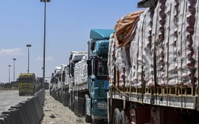 Egyptian trucks carrying humanitarian aid bound for the Gaza Strip queue outside the Rafah border crossing on the Egyptian side on March 23, 2024.