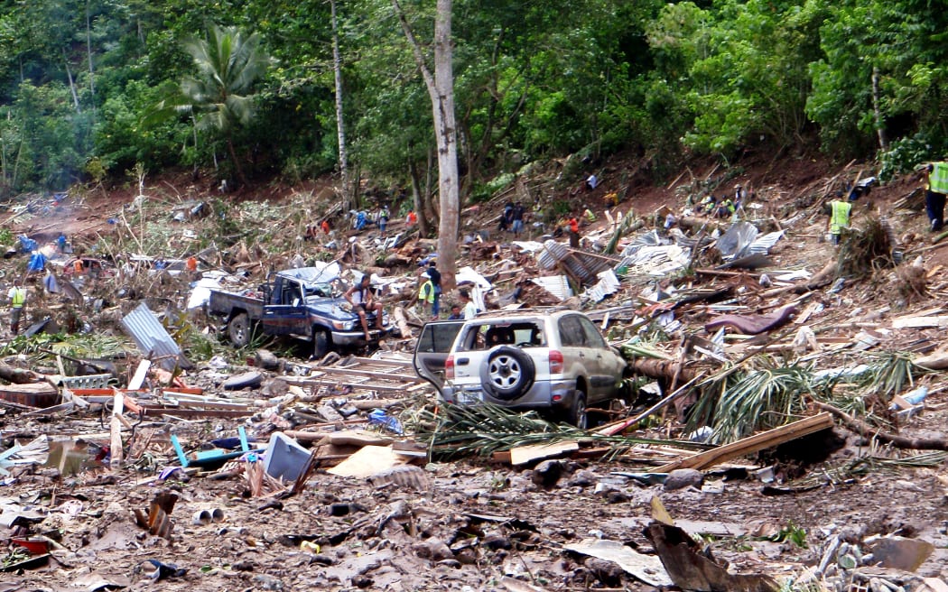 This photo taken on 30 September, 2009 shows rescuers working through the rubble from the devastation caused when the tsunami hit the south coast of Samoa.