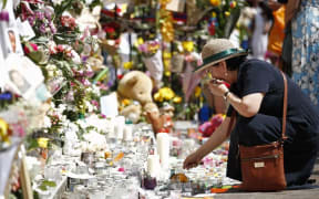 A woman lays flowers in tribute to the victims of London's Grenfell Tower fire.