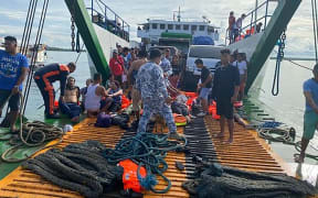 This handout photo taken and released on May 23, 2022 from the Philippine Coastguard shows rescued ferry passengers sitting onboard another ferry off Real town, Quezon province. - At least seven people were killed and scores plucked to safety in the Philippines on May 23 after a fire ripped through a ferry and forced passengers to jump overboard, coast guard and witnesses said. (Photo by Handout / Philippine Coastguard / AFP) / -----EDITORS NOTE --- RESTRICTED TO EDITORIAL USE - MANDATORY CREDIT "AFP PHOTO / PHILIPPINE COASTGUARD" - NO MARKETING - NO ADVERTISING CAMPAIGNS - DISTRIBUTED AS A SERVICE TO CLIENTS