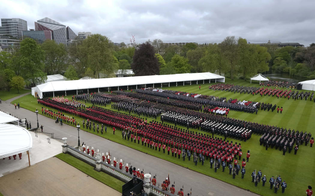 Members of the armed forces stand in formation as they prepare to give a royal salute on the lawn outside Buckingham Palace following the coronation of Britain's King Charles III and Queen Camilla, in central London on May 6, 2023. - The set-piece coronation is the first in Britain in 70 years, and only the second in history to be televised. Charles will be the 40th reigning monarch to be crowned at the central London church since King William I in 1066. Outside the UK, he is also king of 14 other Commonwealth countries, including Australia, Canada and New Zealand. Camilla, his second wife, will be crowned queen alongside him, and be known as Queen Camilla after the ceremony. (Photo by Peter Dejong / POOL / AFP)