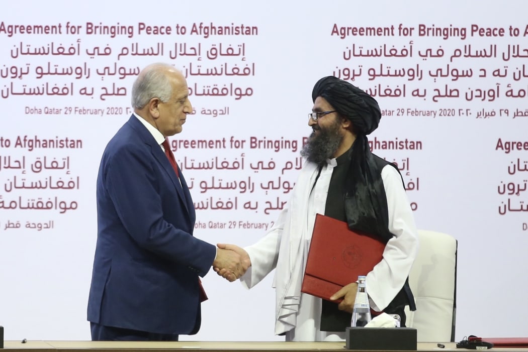 US Special Representative for Afghanistan Reconciliation Zalmay Khalilzad (left) and Taliban co-founder Mullah Abdul Ghani Baradar shake hands after signing the peace agreement between US, Taliban, in Doha, Qatar on 29 February, 2020.