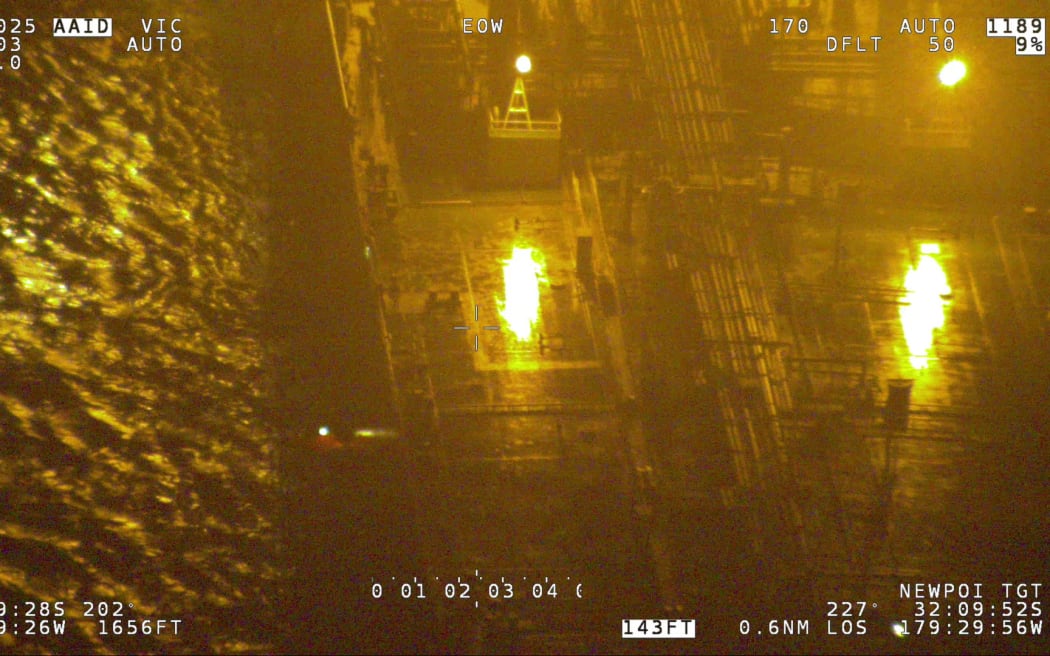 A life raft alongside a merchant vessel.